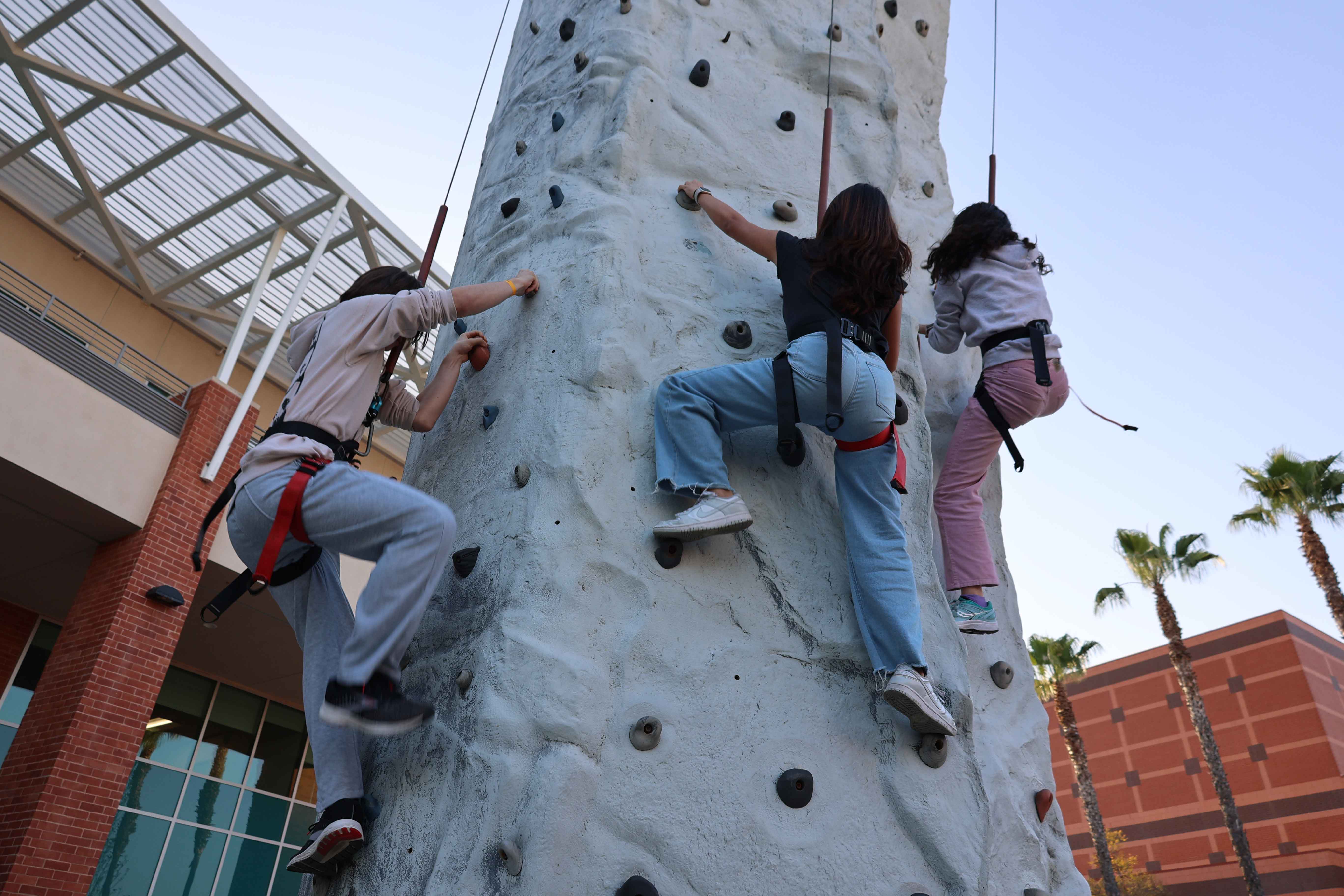 Students shooting basketballs at inflatable game station during Eddie Fest