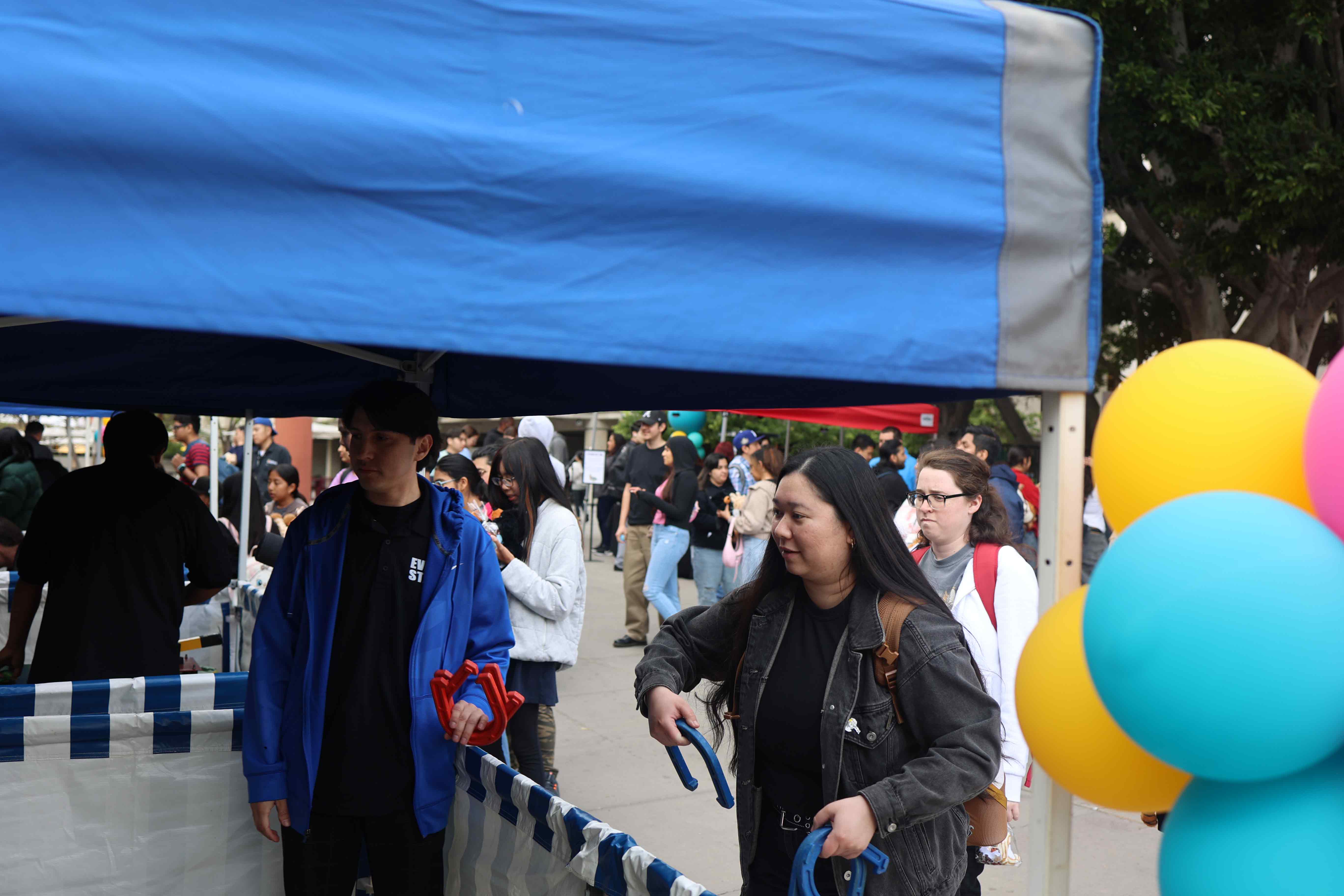 Students playing ring toss game at Eddie Fest booth
